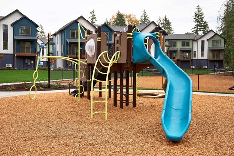 A playground with a blue slide and a yellow climbing frame.