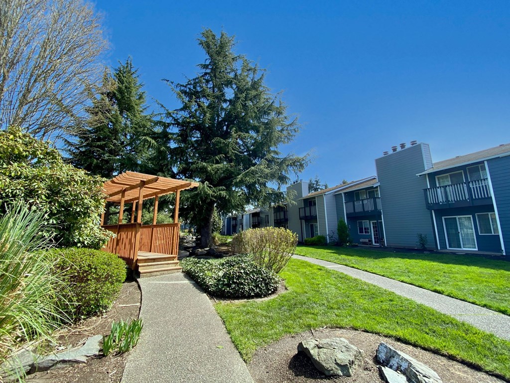 a walkway with a gazebo in front of a apartment building