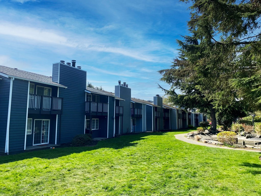 a row of townhomes with green grass and trees