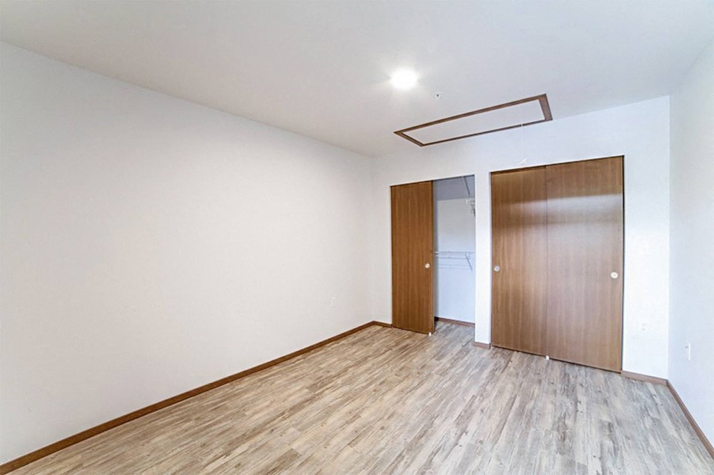 an empty living room with white walls and wood flooring