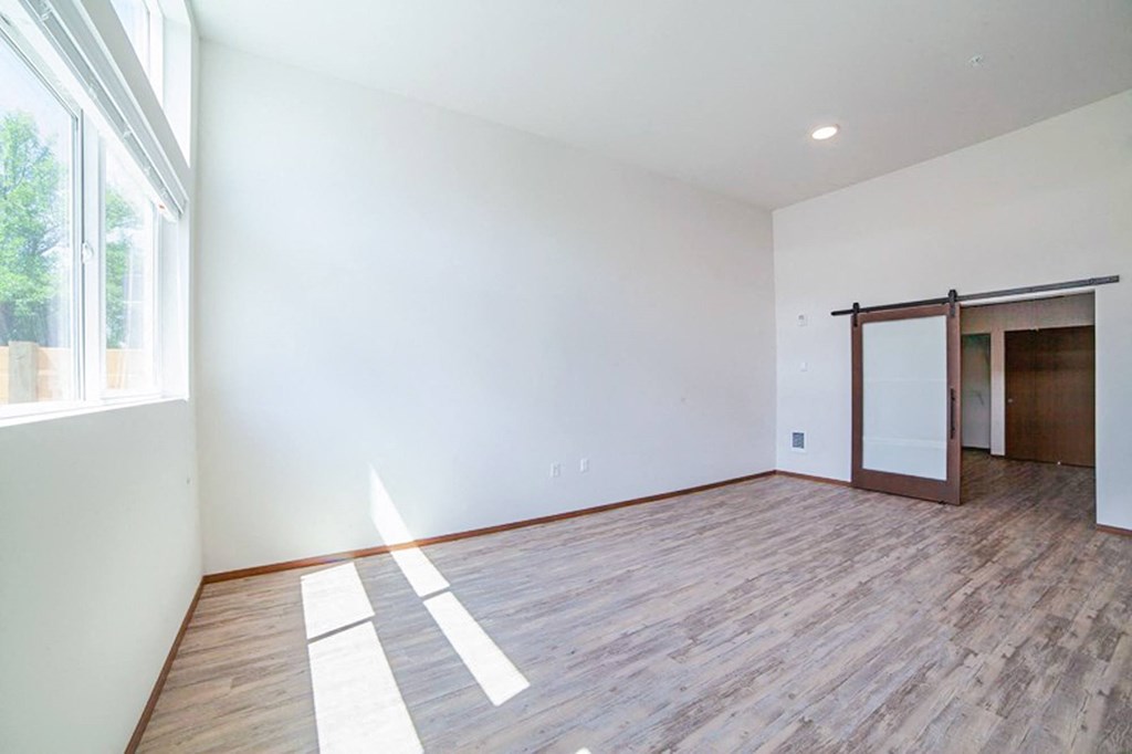 an empty living room with white walls and a sliding glass door