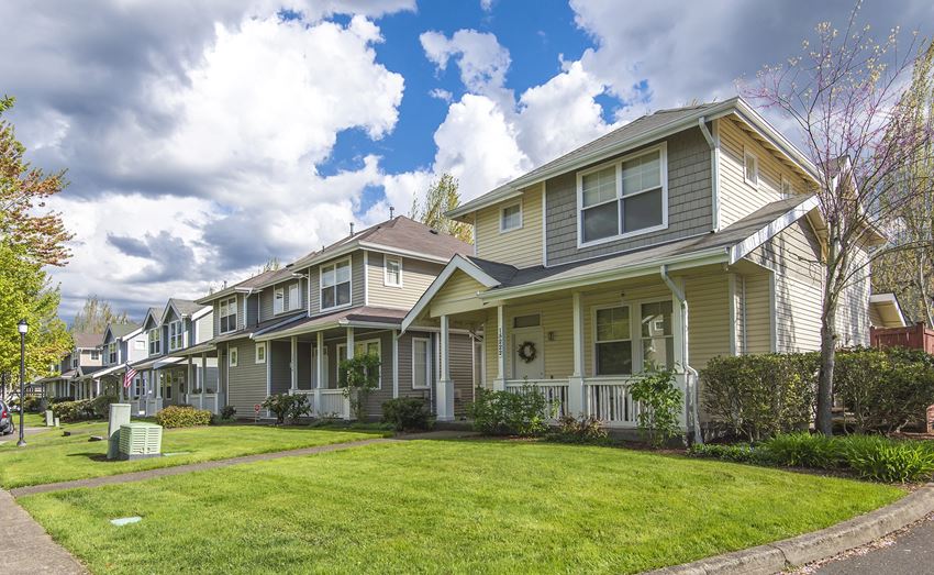 a row of houses on a green lawn