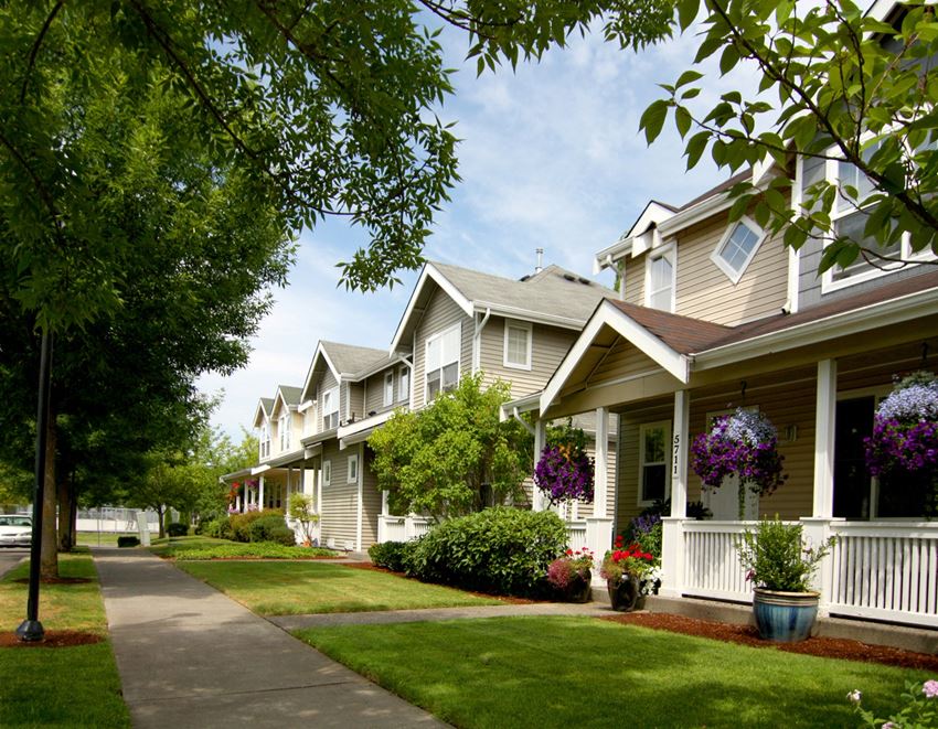 a sidewalk in front of a row of houses