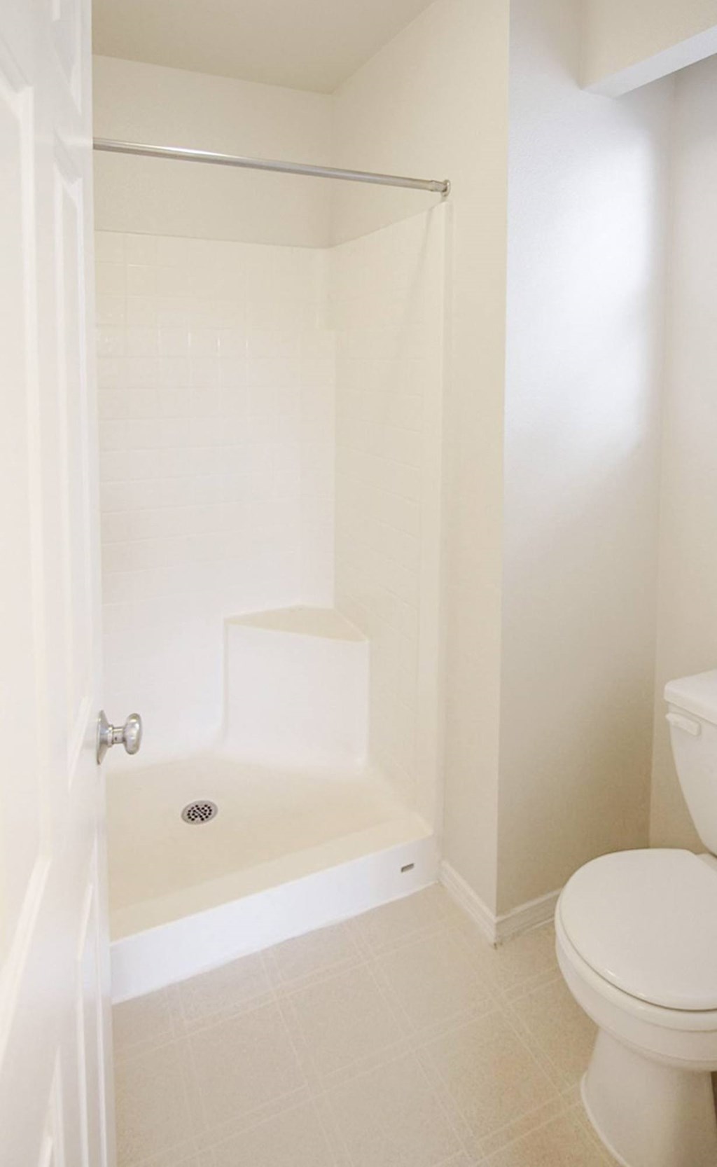 a white bathroom with a shower and a toilet