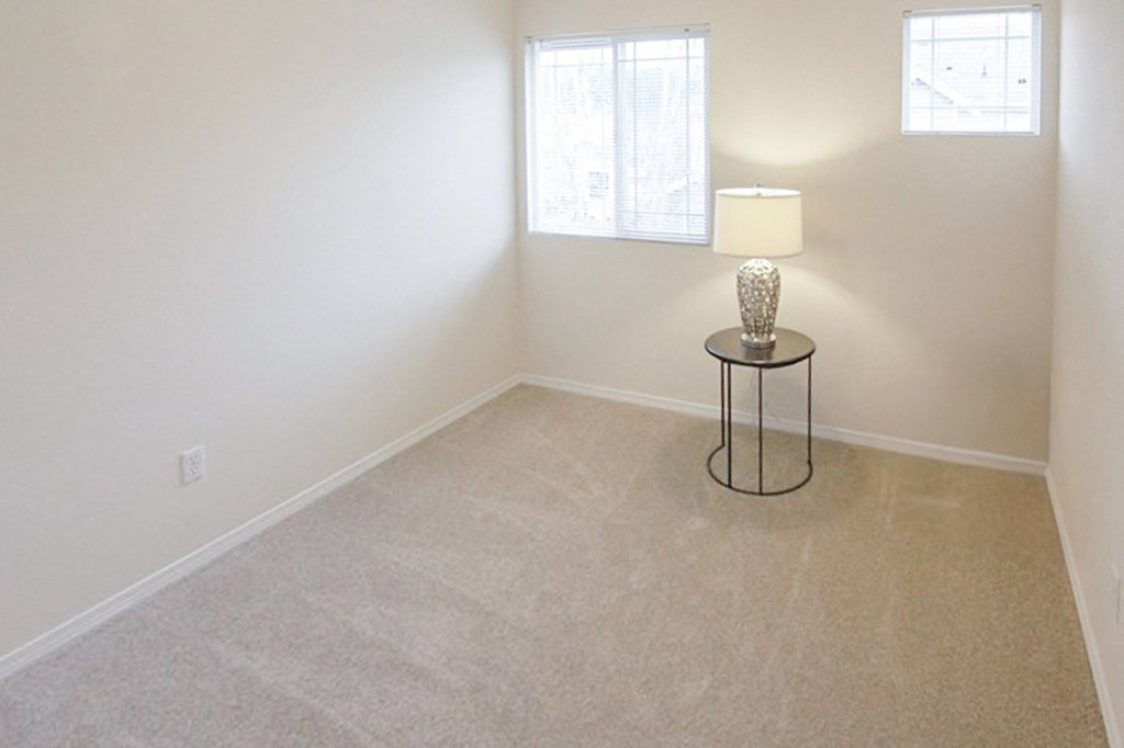 an empty room with a lamp and a table