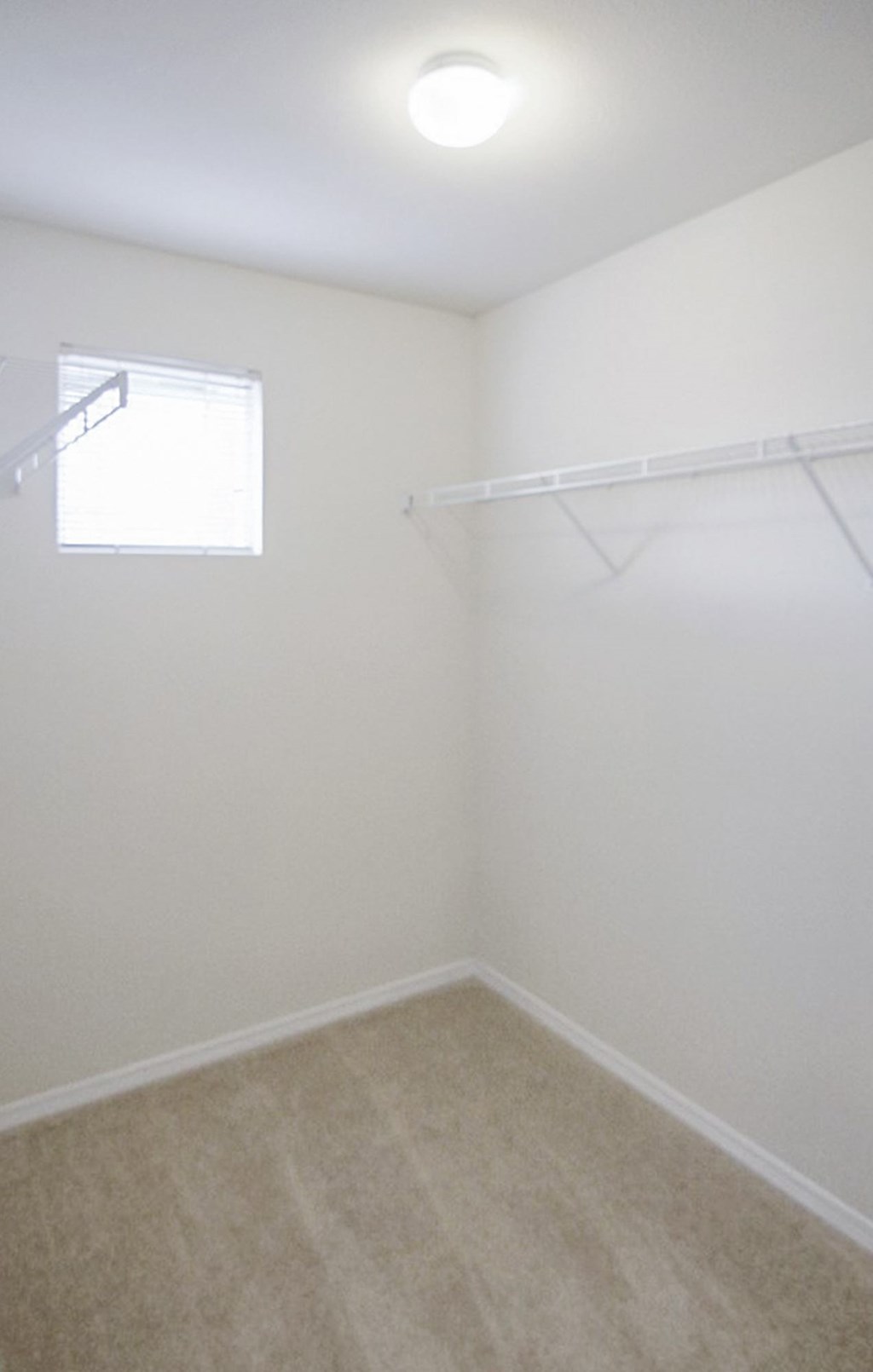 an empty room with white walls and a window
