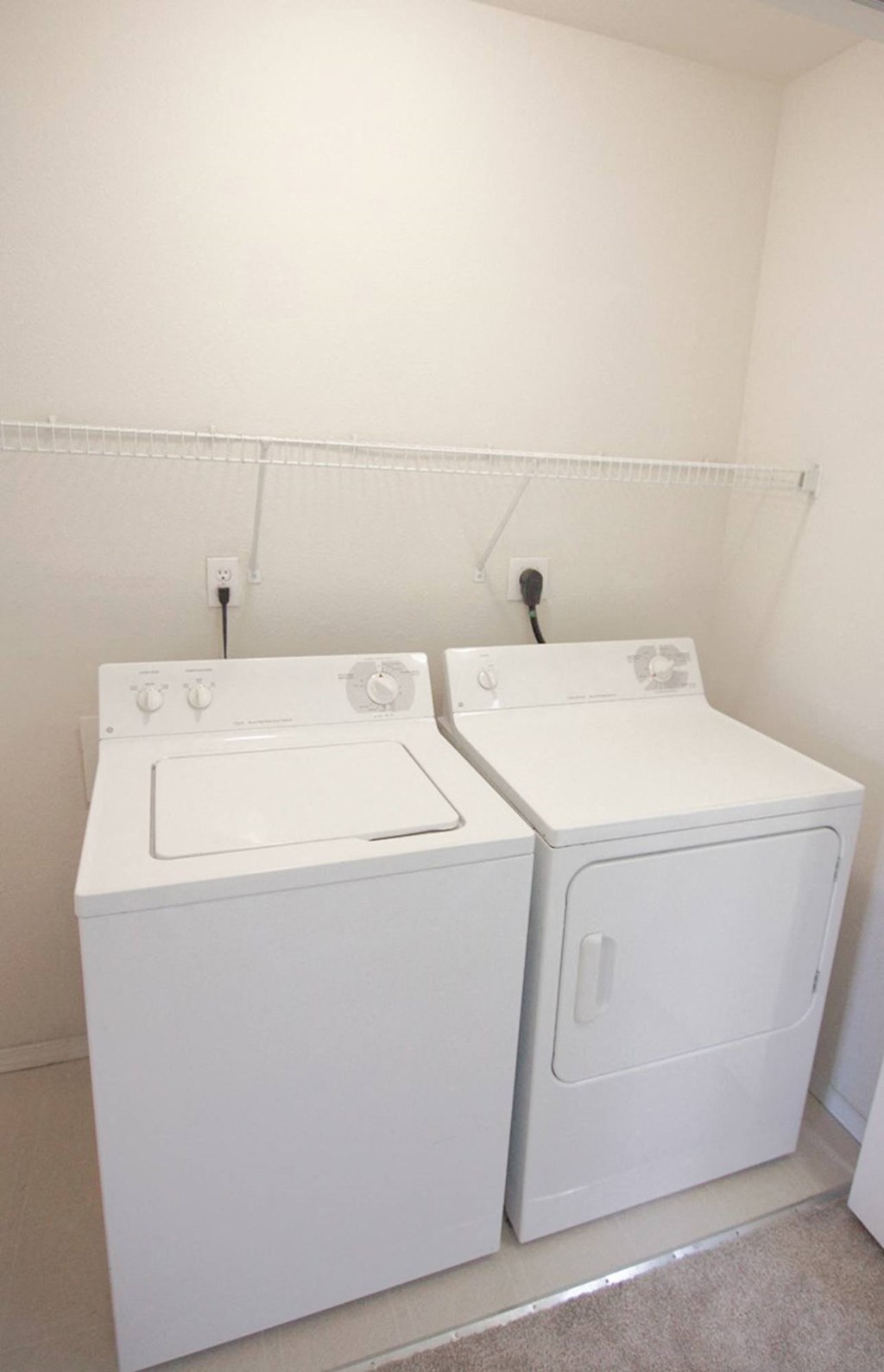 a white washer and dryer in a room with white walls