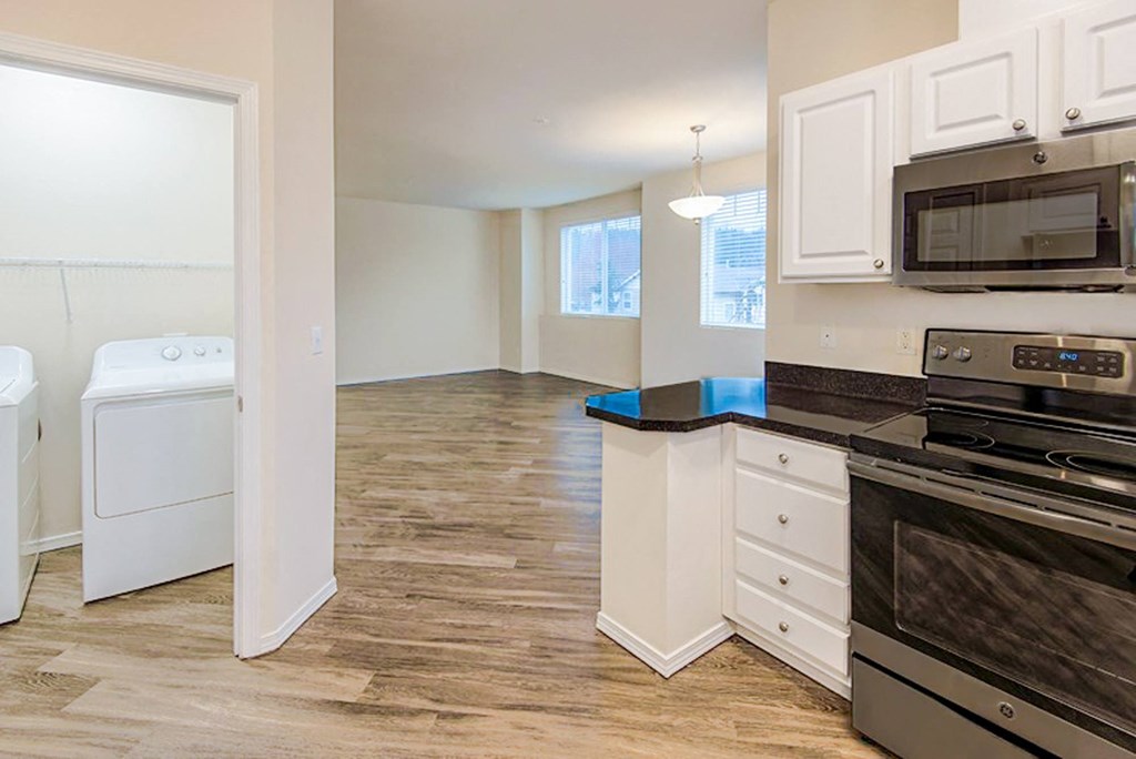 an empty kitchen with a washer and dryer in it