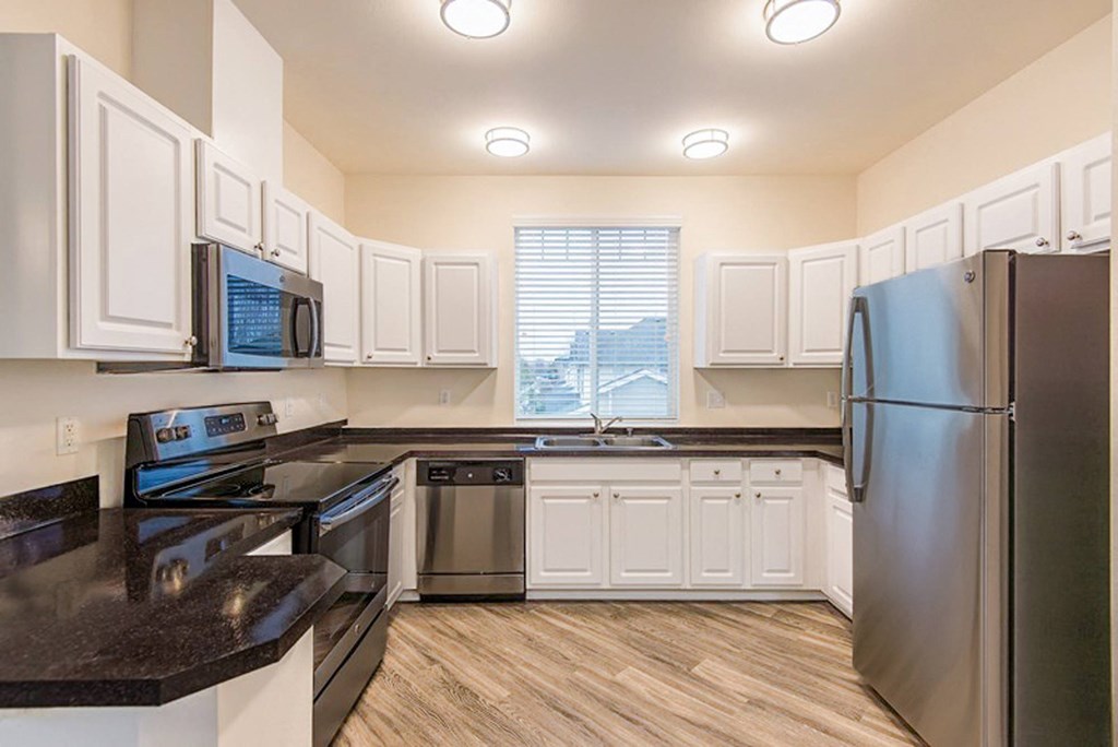 a kitchen with stainless steel appliances and white cabinets
