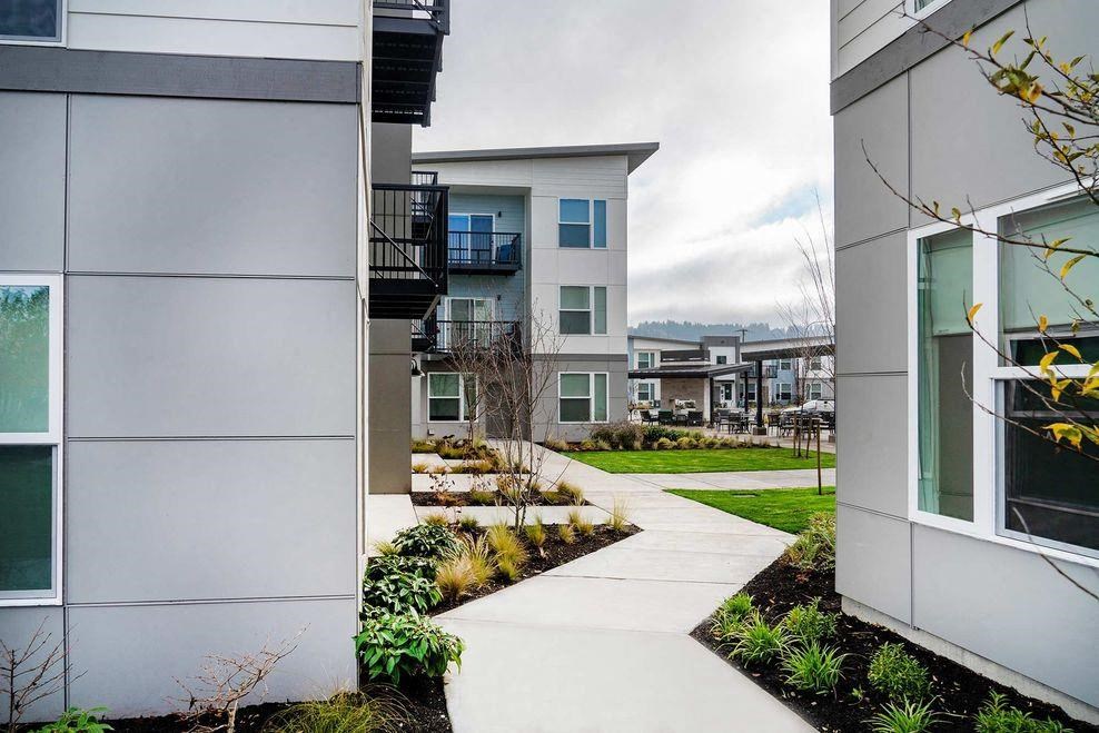 a sidewalk in front of some modern buildings