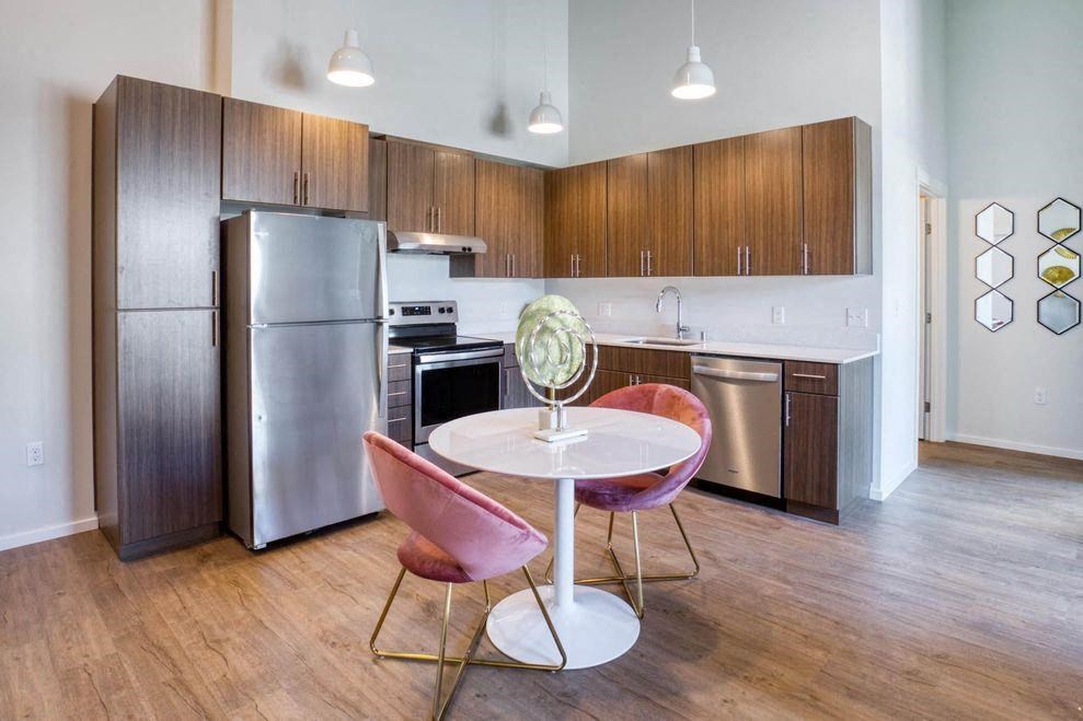 a kitchen with stainless steel appliances and a table and chairs