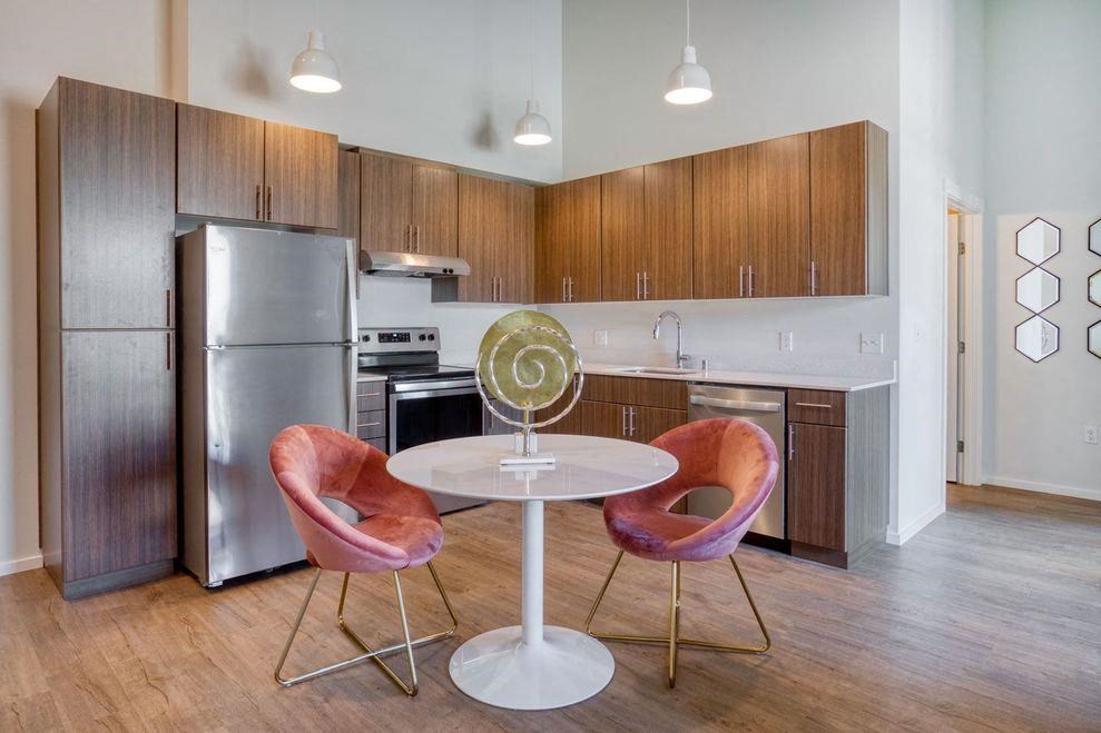 a kitchen with a table and chairs and a refrigerator