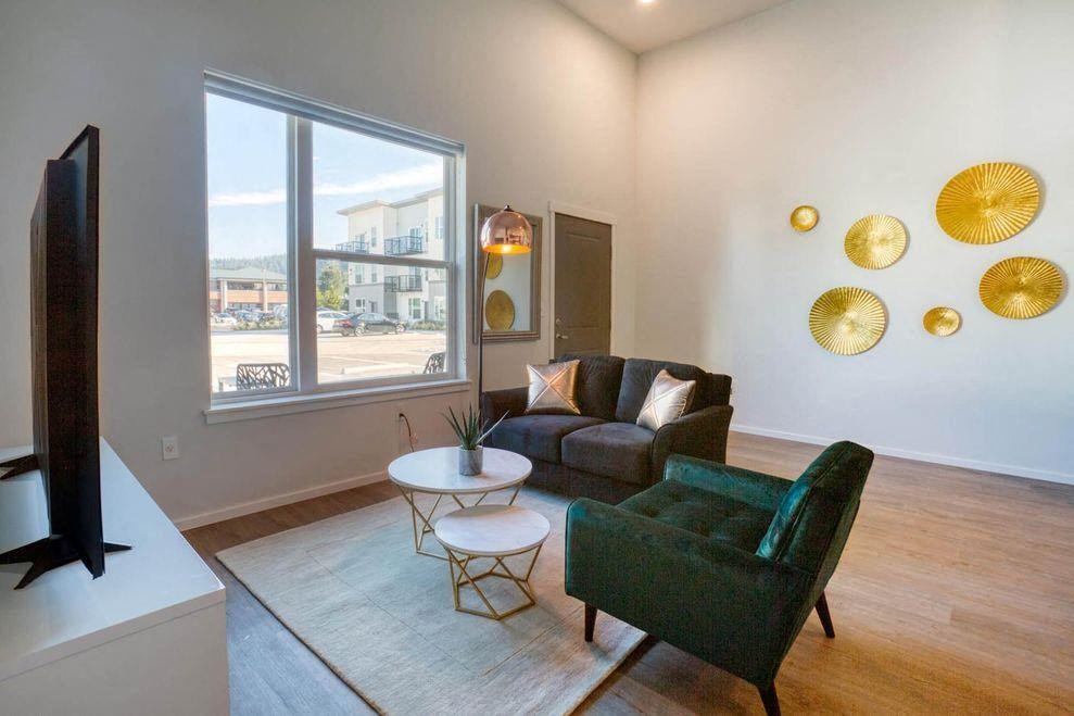 a living room with a couch and a chair and a window