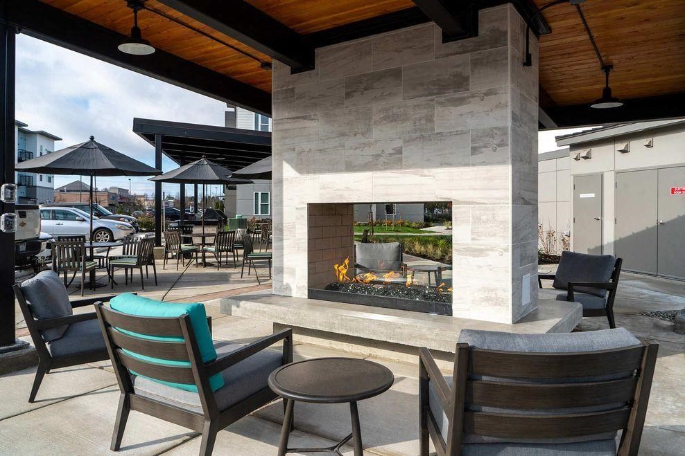 a large fireplace in a patio with chairs and tables