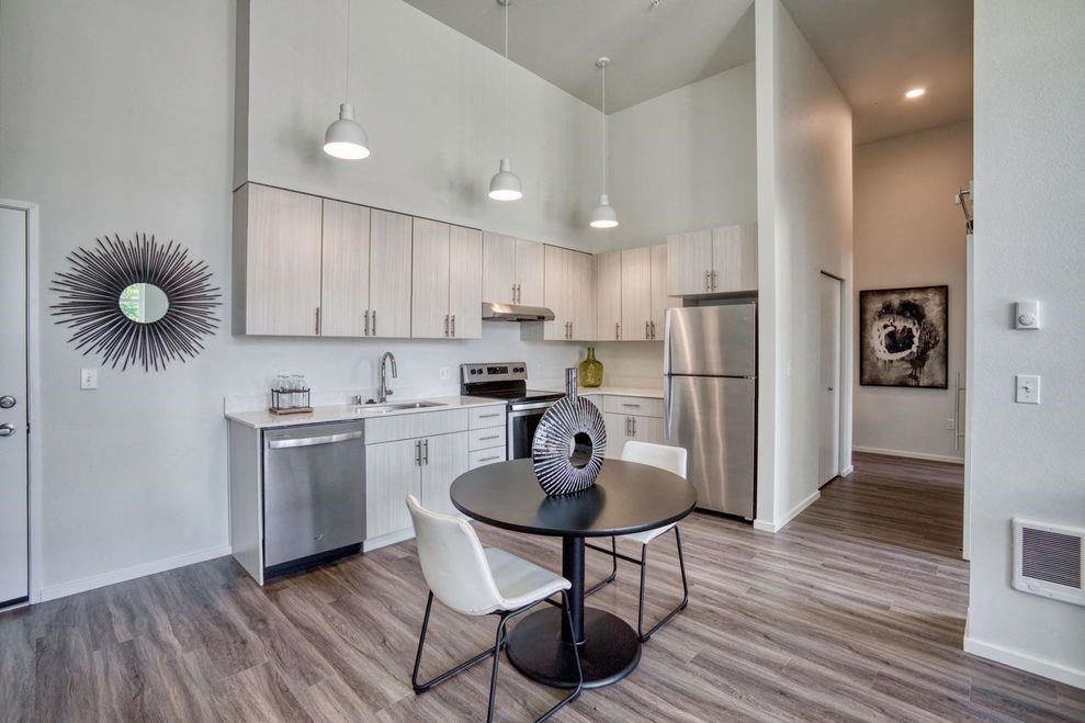 a kitchen with stainless steel appliances and a table and chairs