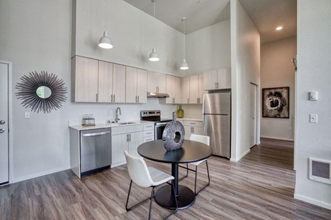 a kitchen with stainless steel appliances and a table and chairs
