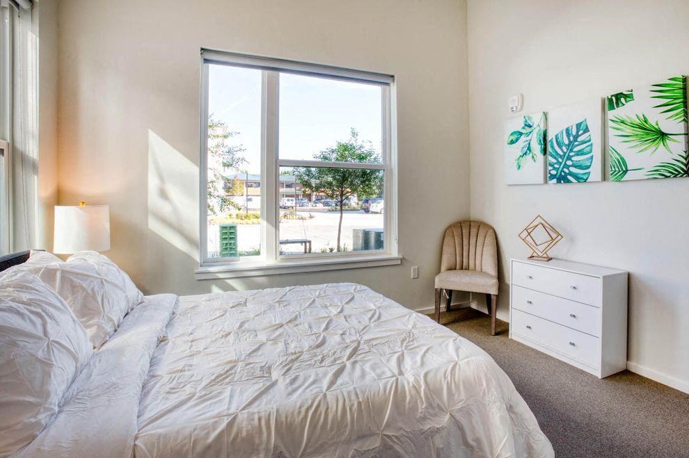 a bedroom with a bed and a large window