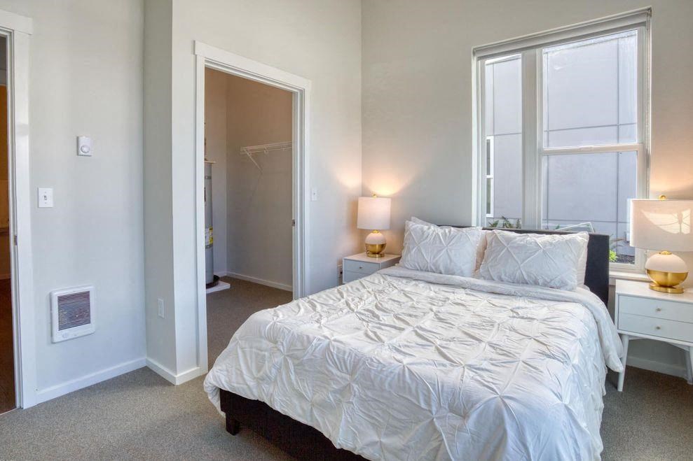 a bedroom with a bed and two windows