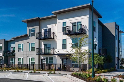 an apartment building with balconies and a sidewalk