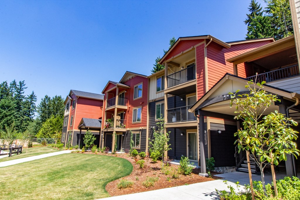 a row of houses with a lawn and trees