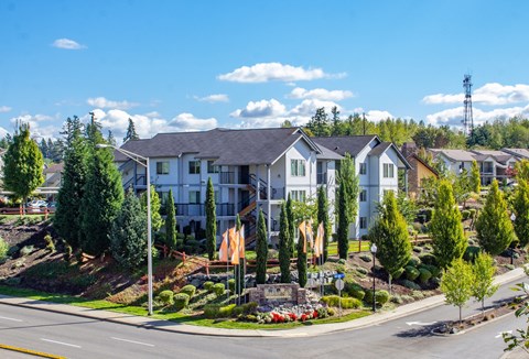 an aerial view of an apartment complex with trees and a street