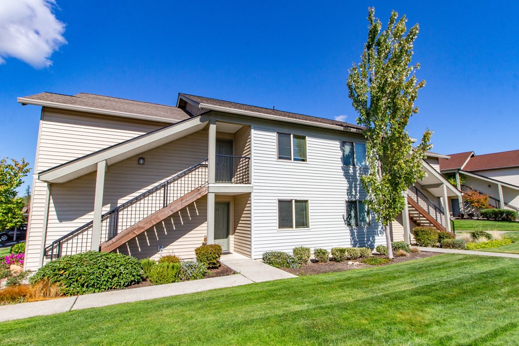 the outlook of a white house with stairs and a lawn