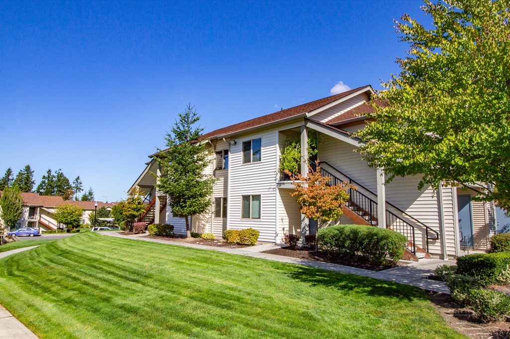the view of a house with a lawn and trees