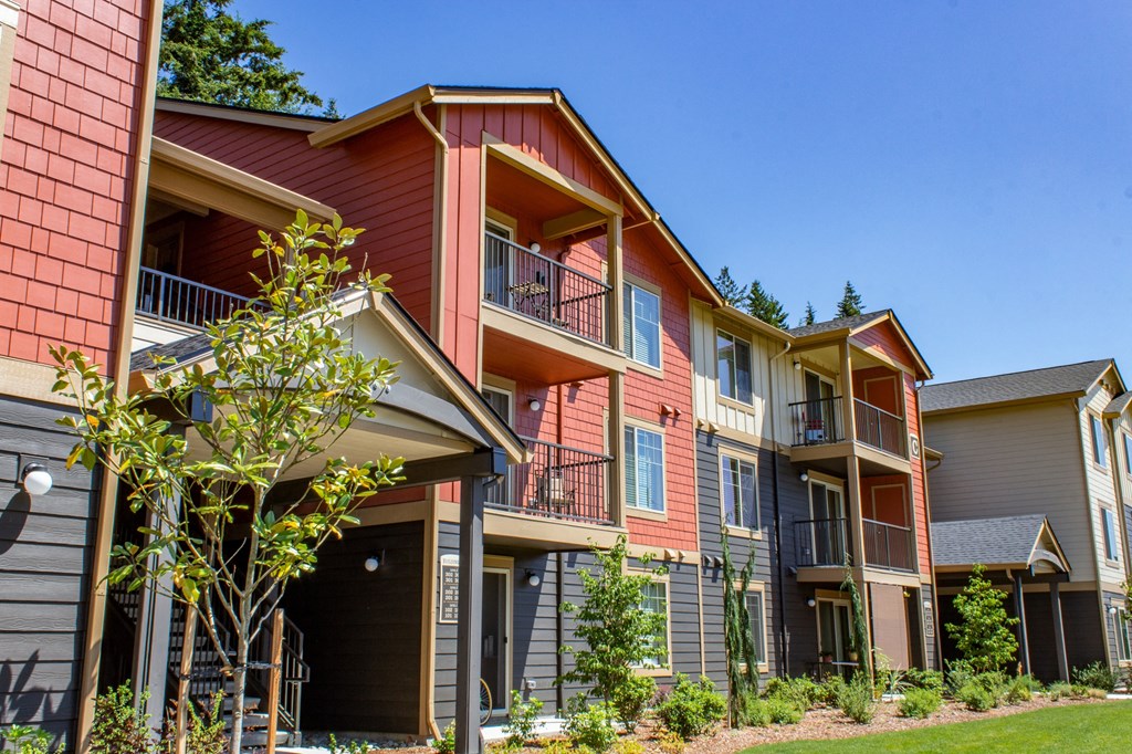 a row of apartments with balconies and a lawn