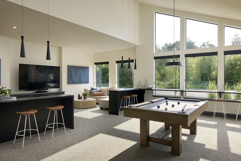 an open living room with a pool table and a flat screen tv