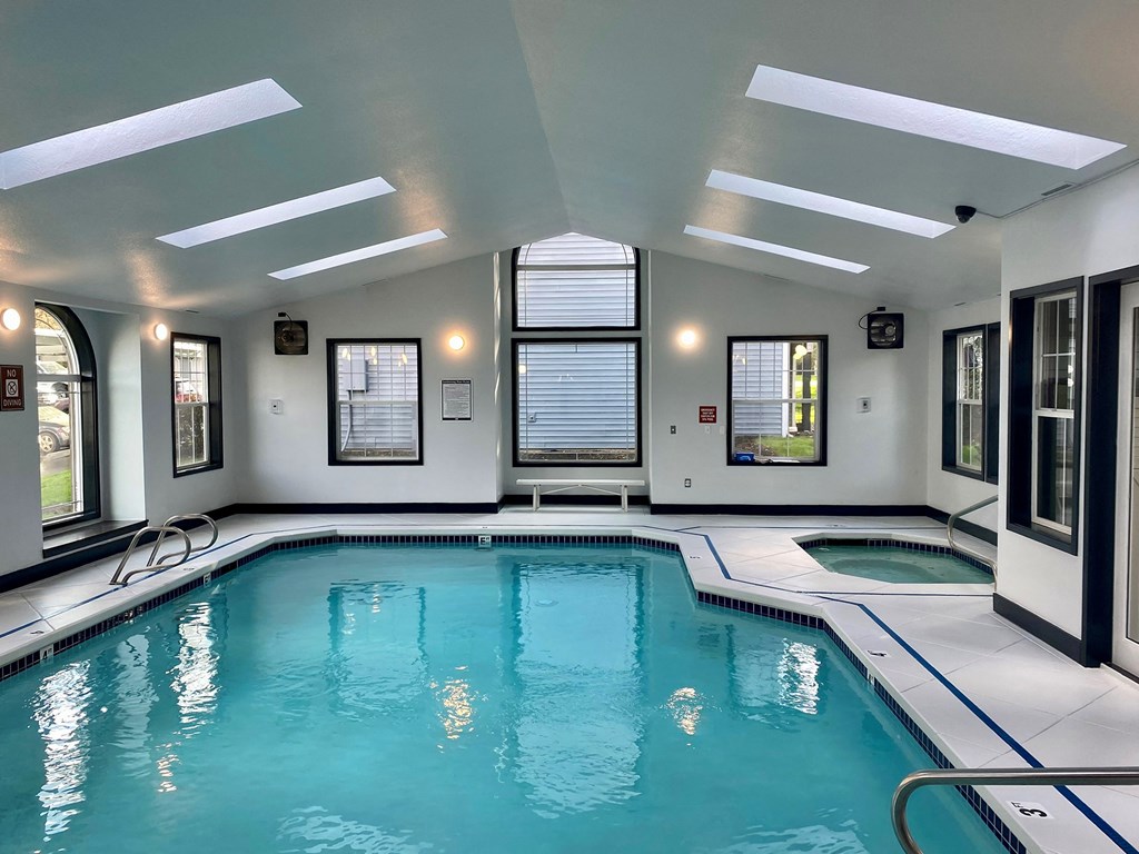 a indoor swimming pool in a building with windows and a ceiling