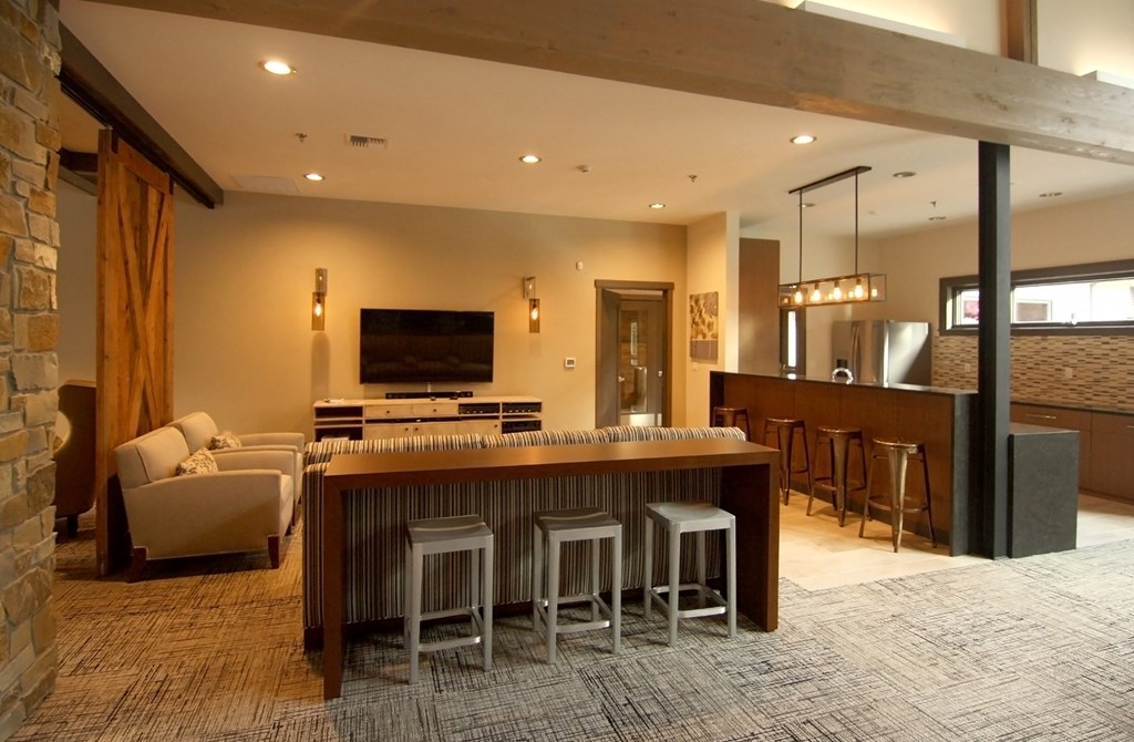 a kitchen with a bar and a living room with a couch and a television