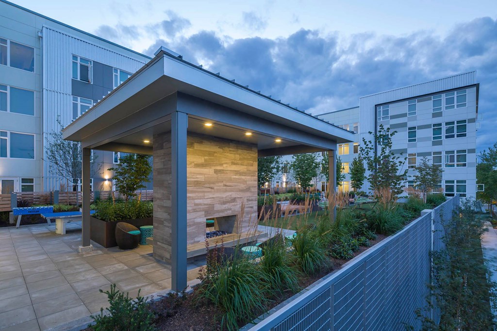 a courtyard with a stone fireplace and a pavilion