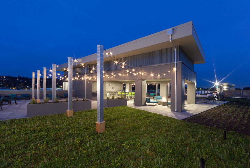 a large building with lights and a lawn