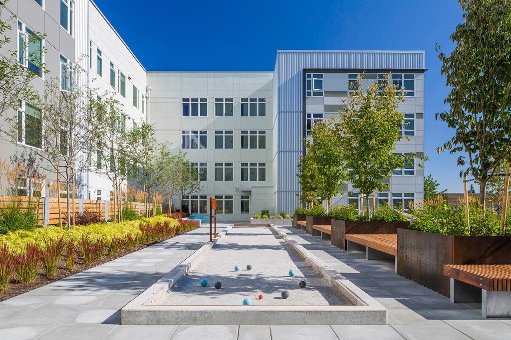 a courtyard with a fountain and benches in front of some buildings