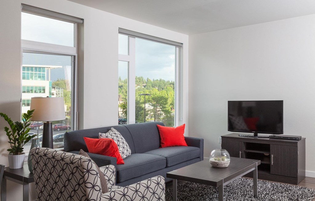 a living room with a couch and chairs and a television