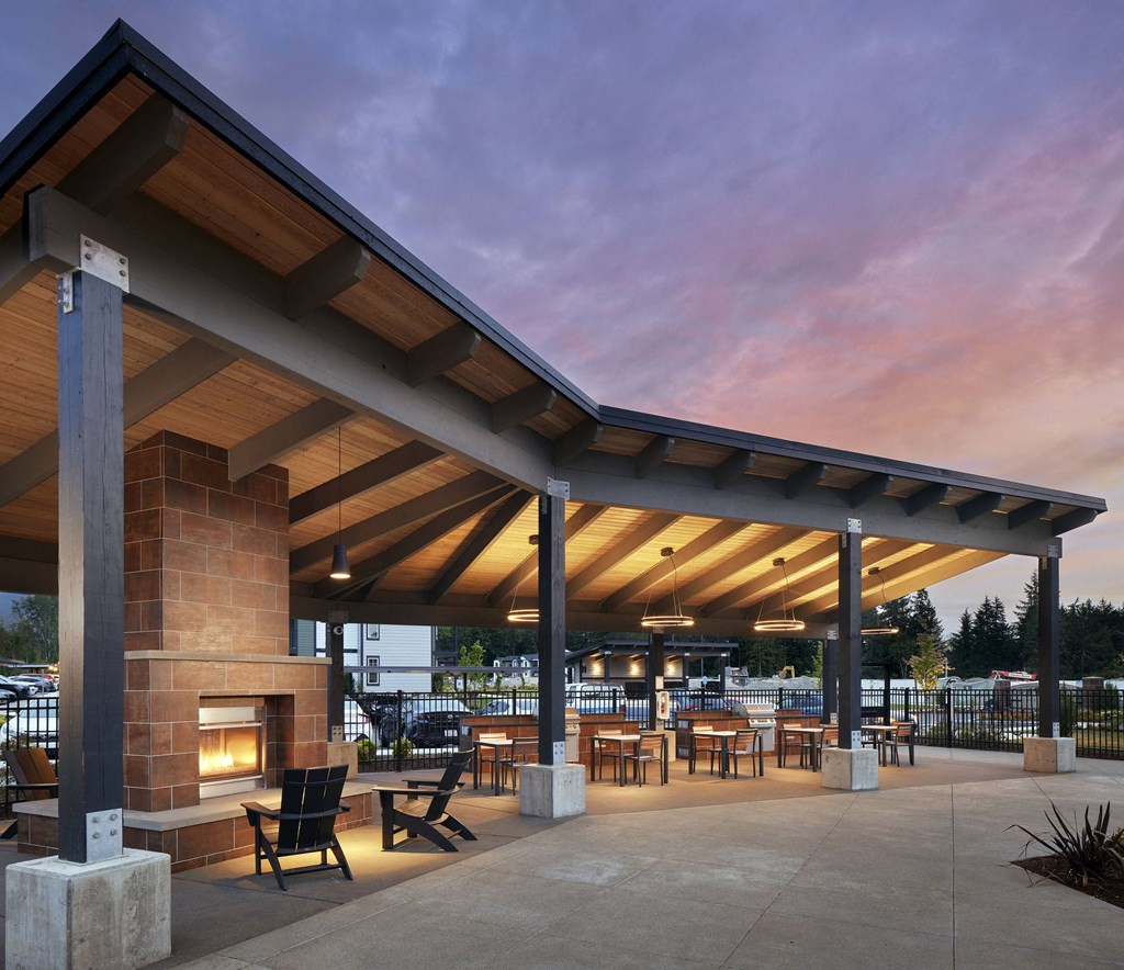 a patio with a fireplace and tables and chairs