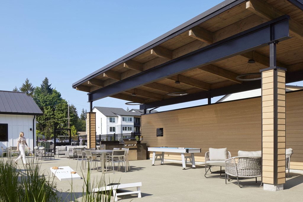 a patio with tables and chairs and a ping pong table