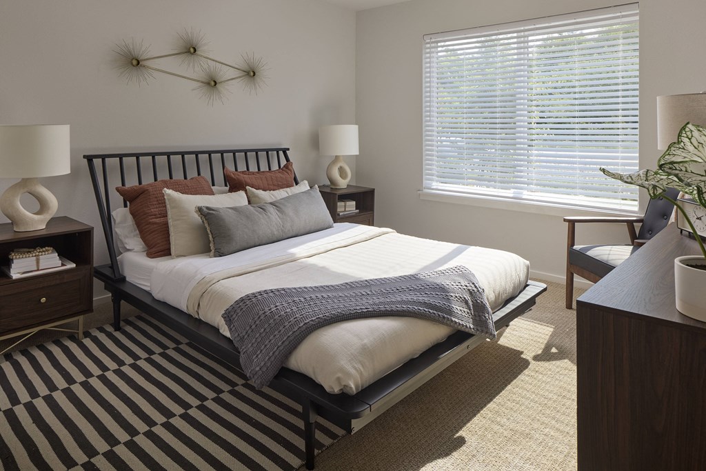 a bedroom with a bed and two windows