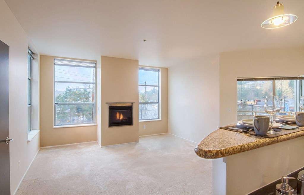 the view of a living room with a fireplace and a kitchen