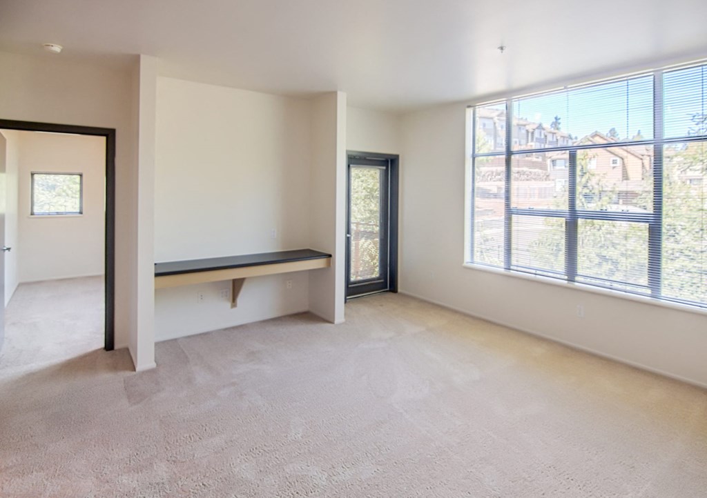 the living room of an empty apartment with a large window