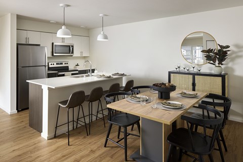 A modern kitchen with a dining table set for two.