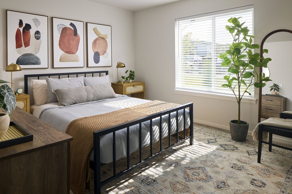 a bedroom with a large bed and two paintings on the wall