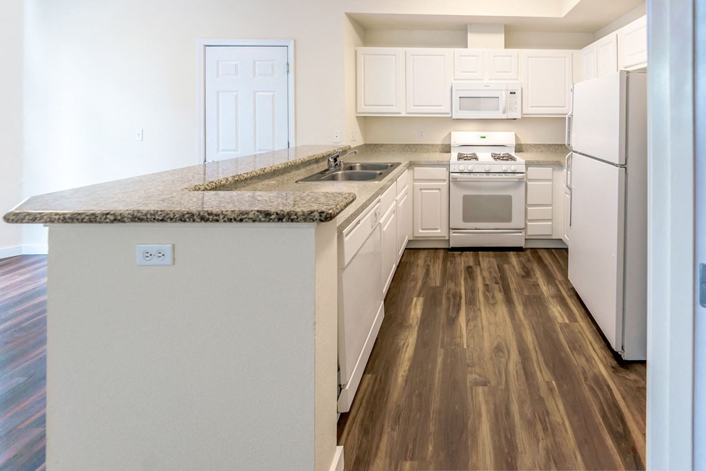 a kitchen with white appliances and a granite counter top