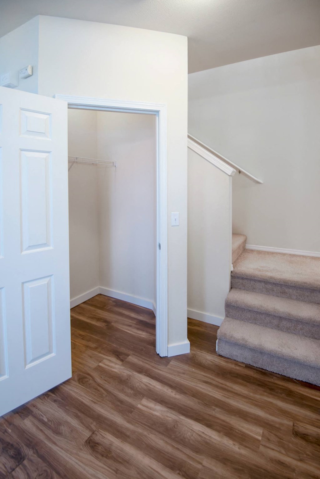 a renovated living room with stairs and a closet