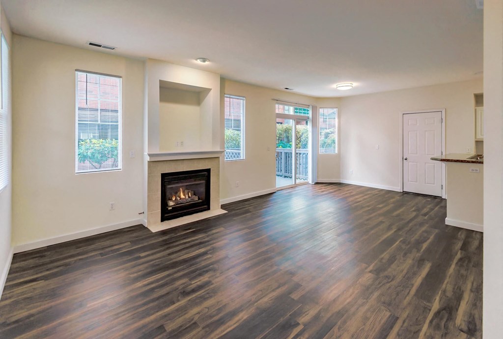 a living room with a fireplace and wooden floors