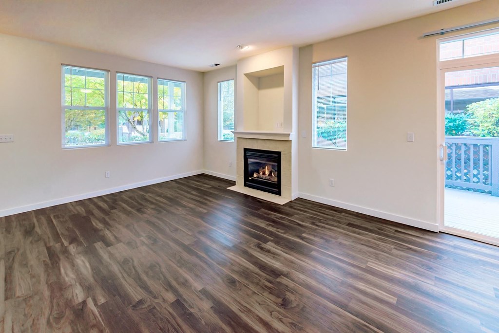 a living room with a fireplace and wooden floors
