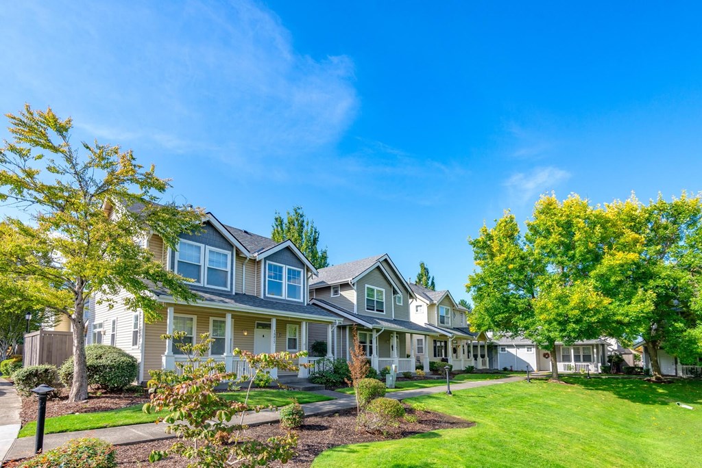 a row of houses with lawns and trees