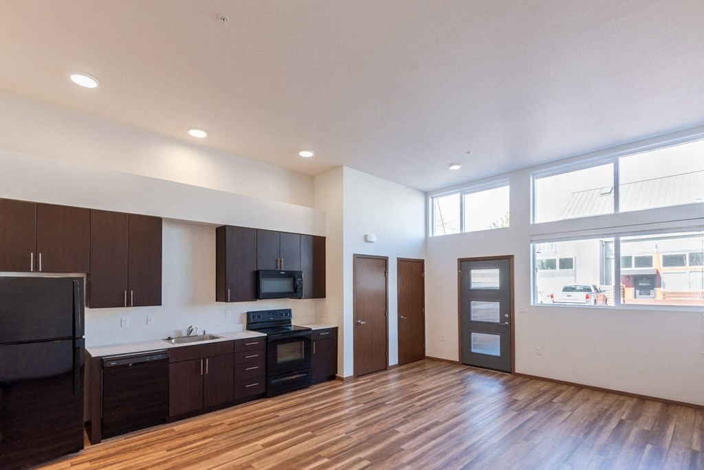 the view of a living room and kitchen in an empty apartment