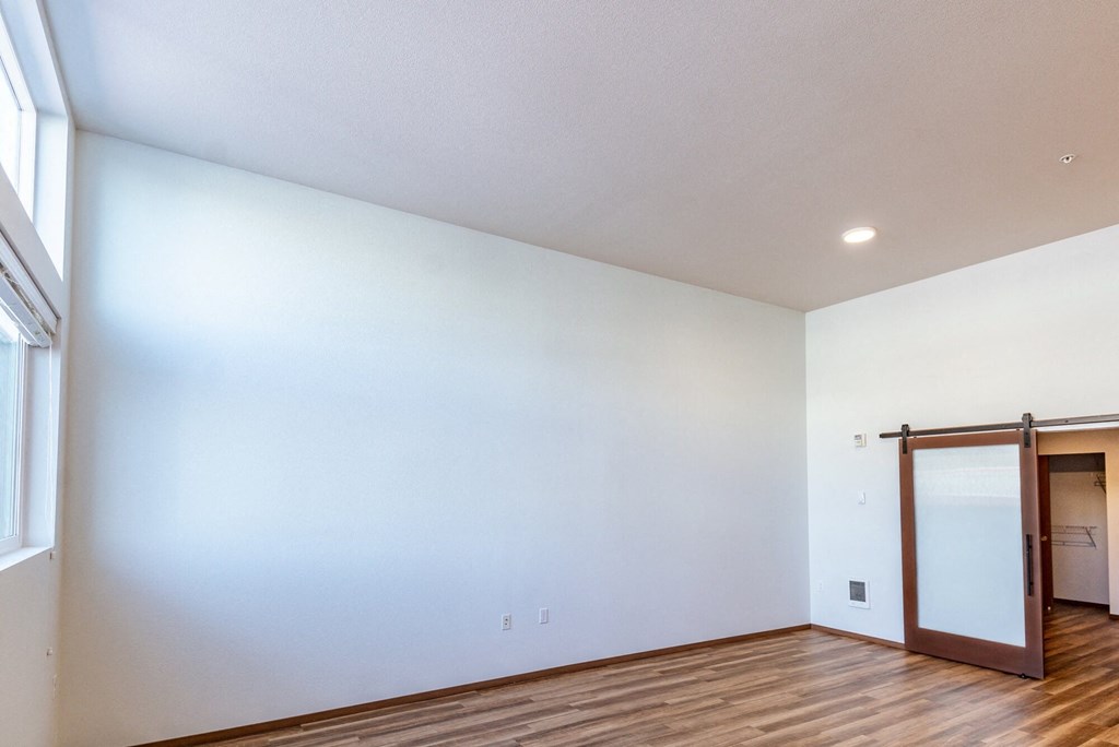 an empty living room with white walls and a sliding glass door