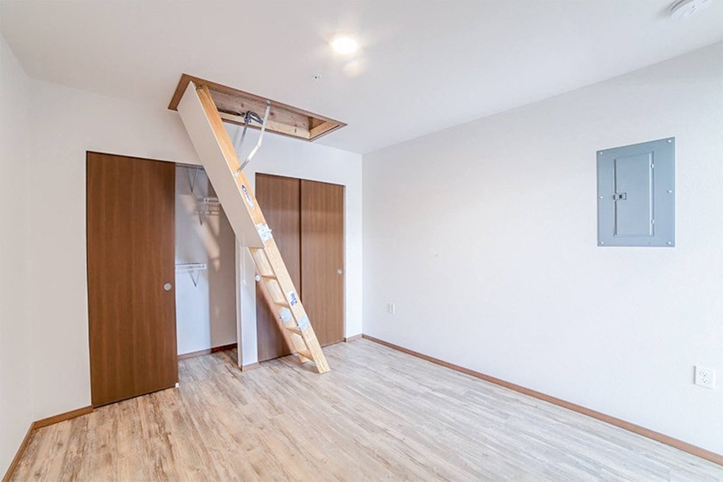 an empty room with a staircase and a wardrobe in it